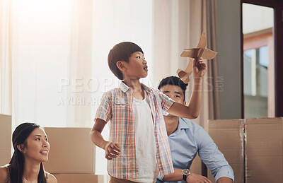 Buy stock photo Shot of a little boy playing with a paper plane at home