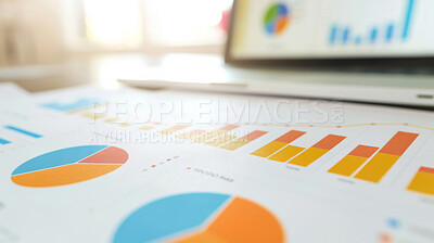 Graphs, paper and laptop on desk for analysis, information and market research with financial statistics. Analytics, economics and accounting with profit, assets and stocks for investment with report