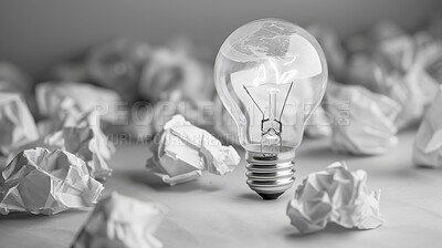 Lightbulb, ideas and crumpled paper for creative solution, writing and brainstorming on desk. Research, planning and inspiration with power, solution or problem solving for startup project or career