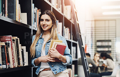 Buy stock photo Portrait of a happy young woman carrying books in a library at college