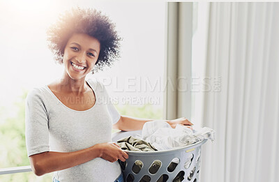Buy stock photo Cropped shot of an attractive young woman holding a washing basket at home