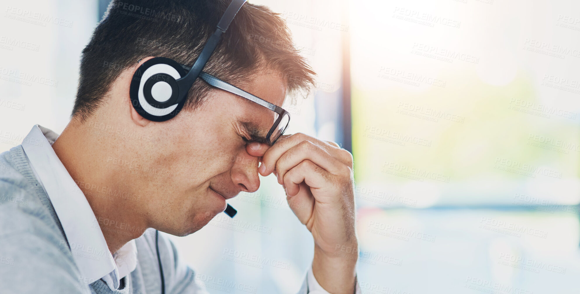 Buy stock photo Man, headset and headache in workplace or job as virtual assistant, customer service agent and employee. Male person, stress and burnout with eye strain, pain or migraine as frustrated in discomfort