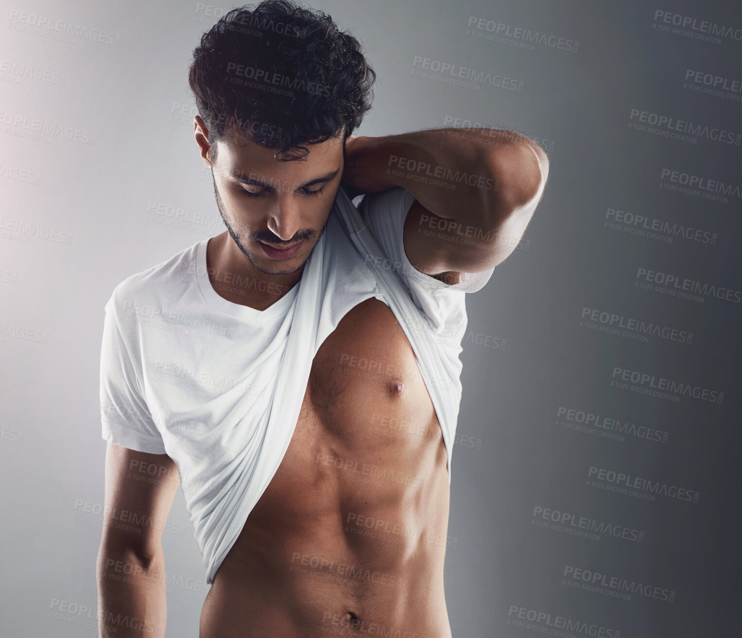 Buy stock photo Abs, man and tshirt in studio with confidence, sensual and fitness on gray background. Gym, healthy body and male athlete with muscle development on stomach, inspiration and pride for progress