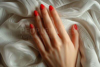 Woman, hand and manicure with red nail polish for beauty, cosmetics or treatment on silk sheets above. Top view or closeup of female person with finger art, spa treatment or style for salon or care