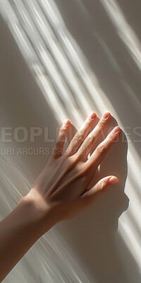 Hand, light and person touching wall for sense of feel, texture or warmth closeup in studio. Fingers, shadow and sun with adult rubbing smooth surface for consistency, grain or quality in summer