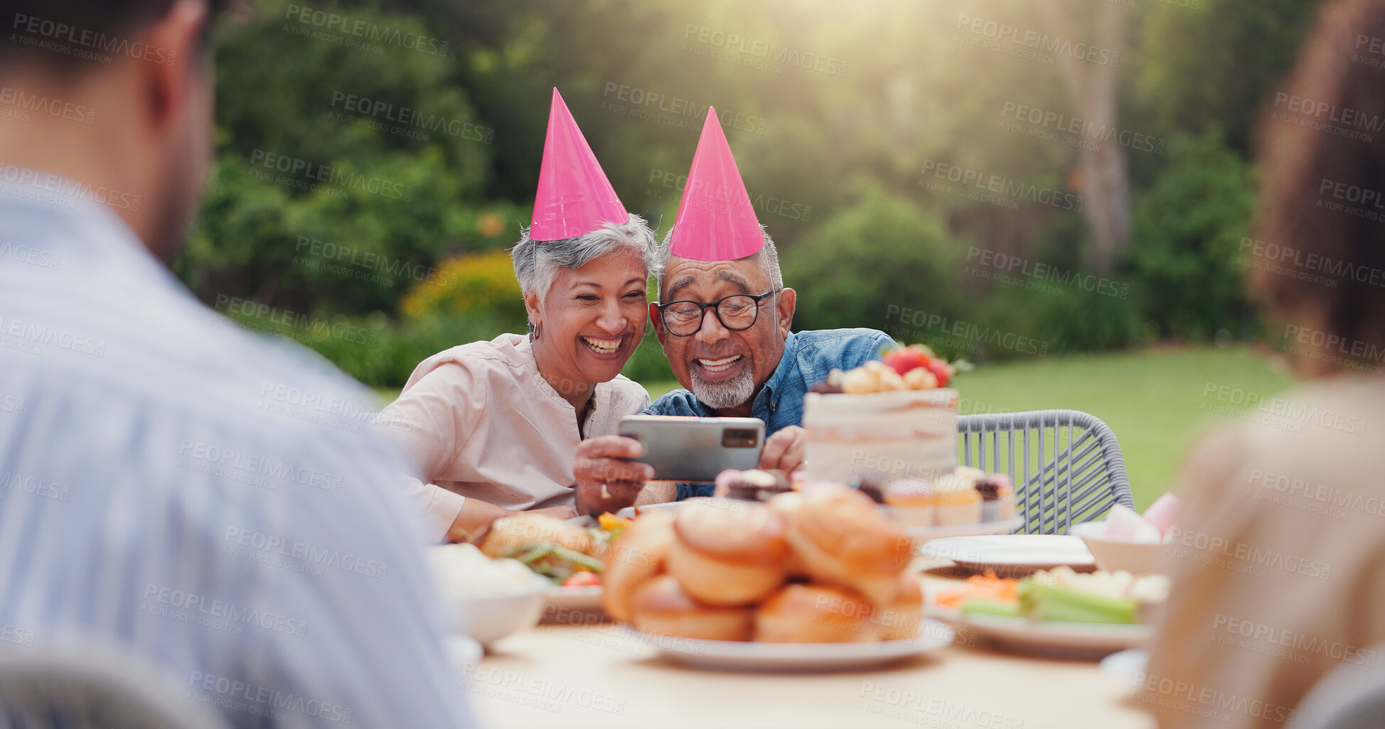 Buy stock photo Elderly, couple and happy with video call at birthday party for celebration, laughing and memories in garden. Senior, man and woman with smartphone for photography, gathering and event in backyard