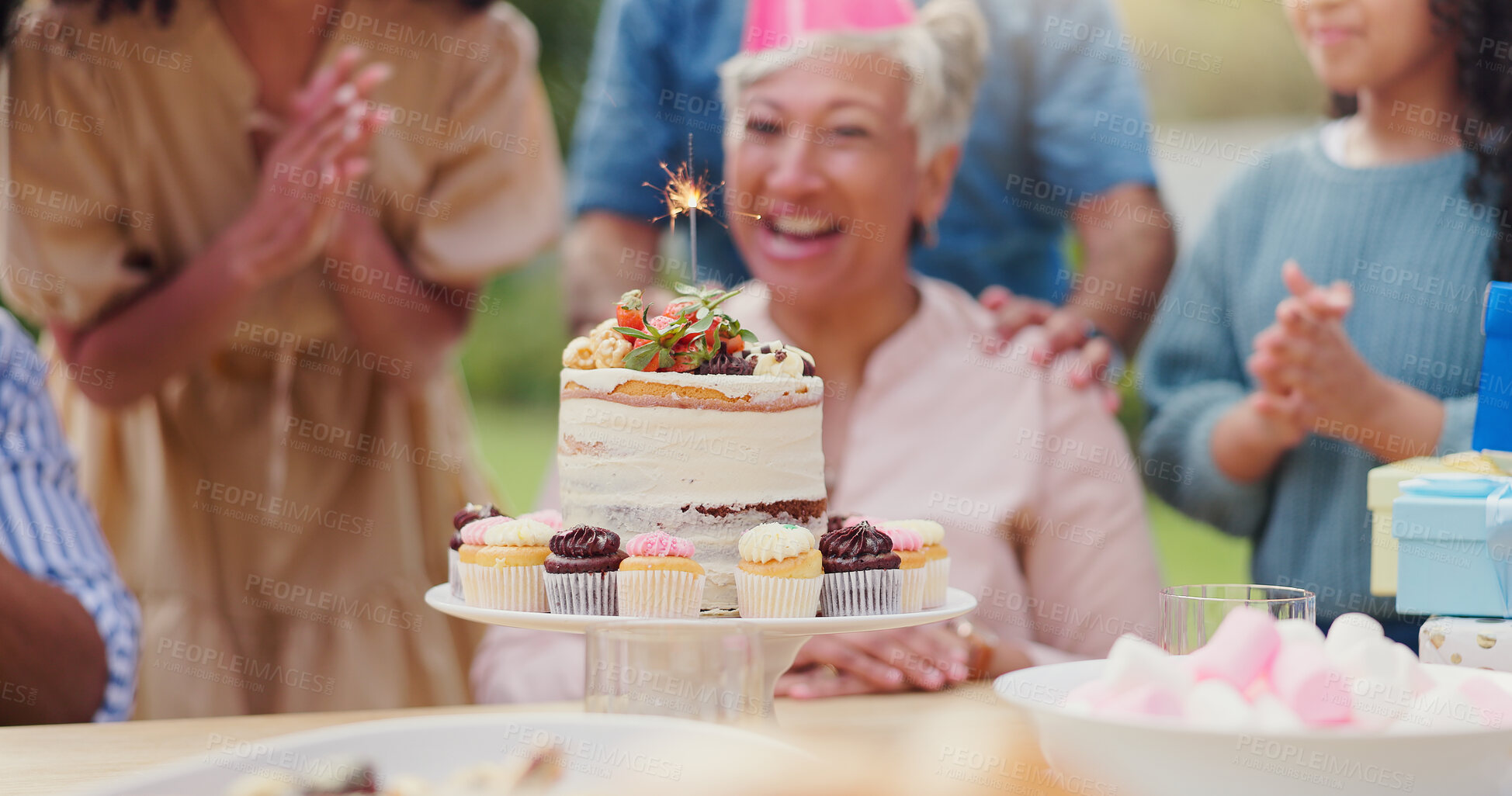 Buy stock photo Birthday cake, sparkler and party with family for celebration, applause and surprise in garden of home. Dessert, grandparents and kids with cupcake, clapping hands and happiness for event in backyard