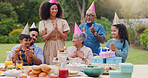 Family, clapping hands and happy with hat at birthday party for celebration, surprise or sparkler in garden of home. Grandparents, parents and kids with applause for gathering and event in backyard