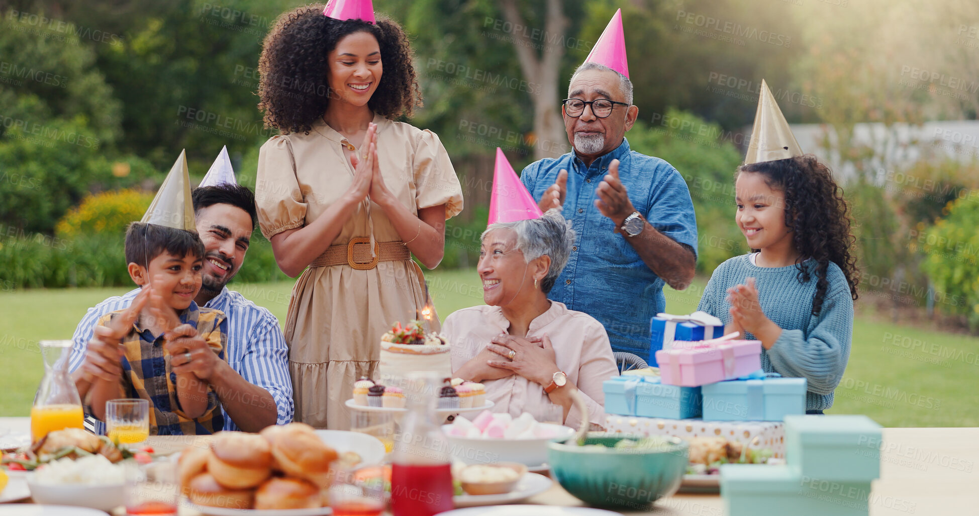 Buy stock photo Happy birthday, celebration and big family with cake, surprise and singing for grandmother at home or garden. Excited senior woman, parents and kids or children with love, clapping and appreciation