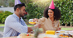 Happy birthday, celebration and couple with orange juice in backyard for brunch, meal or bonding outdoor. Family, lunch and people with food on patio for reunion, event or social gathering on weekend