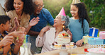 Senior woman, birthday cake and family in garden with applause, celebration and happy together for party. Man, women and children in grandparents backyard with present, dessert and love in summer