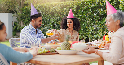 Family, eating and happy with hat at birthday party for celebration, surprise or conversation in garden of home. Couple, parents and kids with drinks for gathering and event in backyard of house