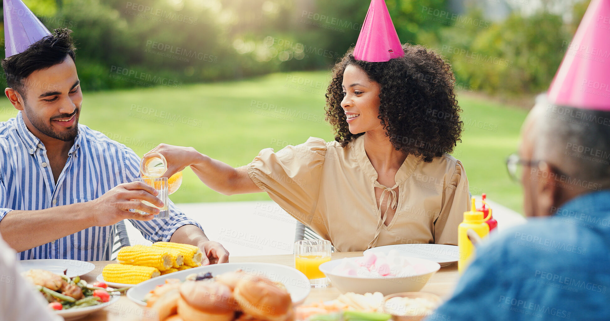 Buy stock photo Happy birthday, celebration and couple with orange juice in backyard for brunch, meal or bonding outdoor. Family, lunch and people with food on patio for reunion, event or social gathering on weekend