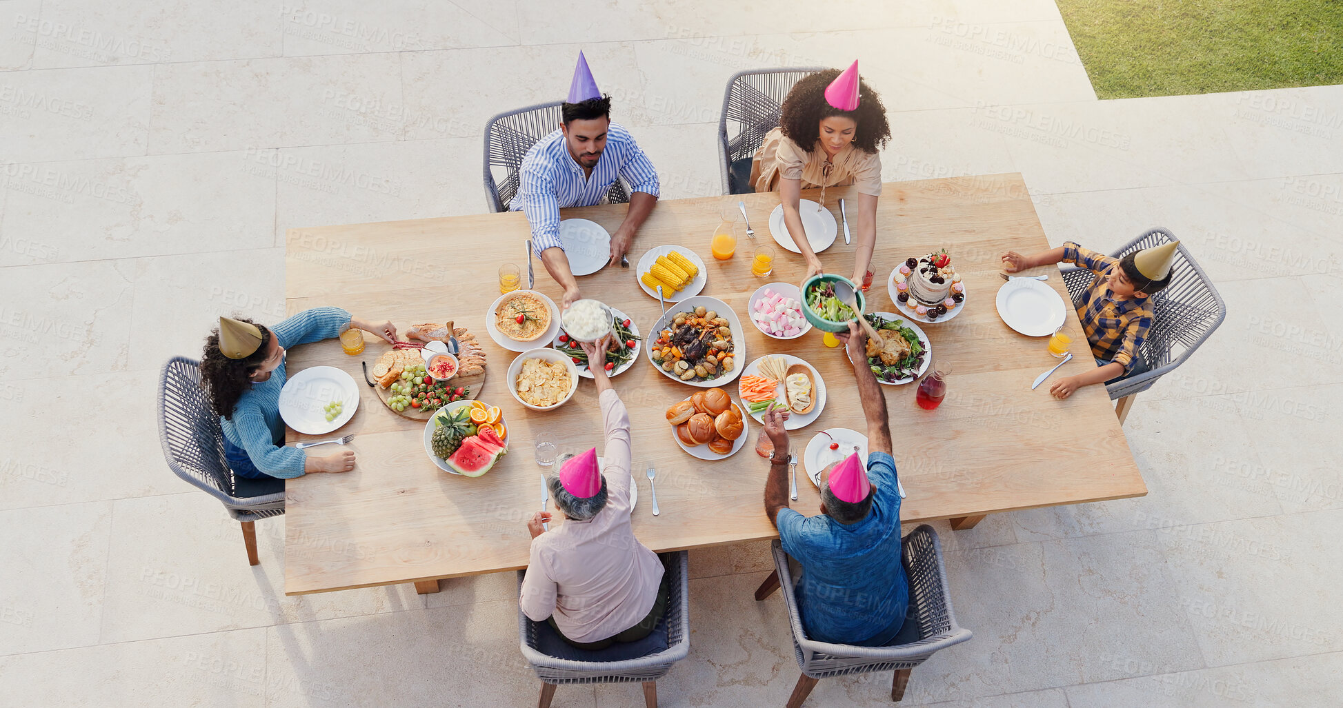 Buy stock photo Happy family, above and birthday party in garden with love, sharing and eating to bond together for lunch. Generations, kids or celebrate by food on green backyard, nutrition and roast meat on table