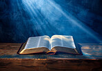 Open book, bible and sunlight on table for christianity with salvation from heaven, knowledge or trust in God. Holy story, religion study and light on scripture for spiritual healing, guide or gospel