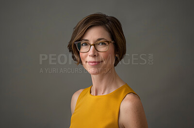 Corporate, portrait and mature executive assistant in studio on gray background for administration. Confident, face and glasses with professional business woman at work for company mission or vision