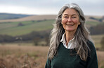 Mature woman, portrait and outdoor breeze for peace, vacation and morning to relax in field. Female person, calm and holiday in retirement for wellness, wind and smile for health in Netherlands