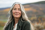 Mature woman, portrait and outdoor hill for peace, vacation and morning to relax in forest field. Female person, calm and holiday in retirement for wellness, trees and smile for health in Netherlands