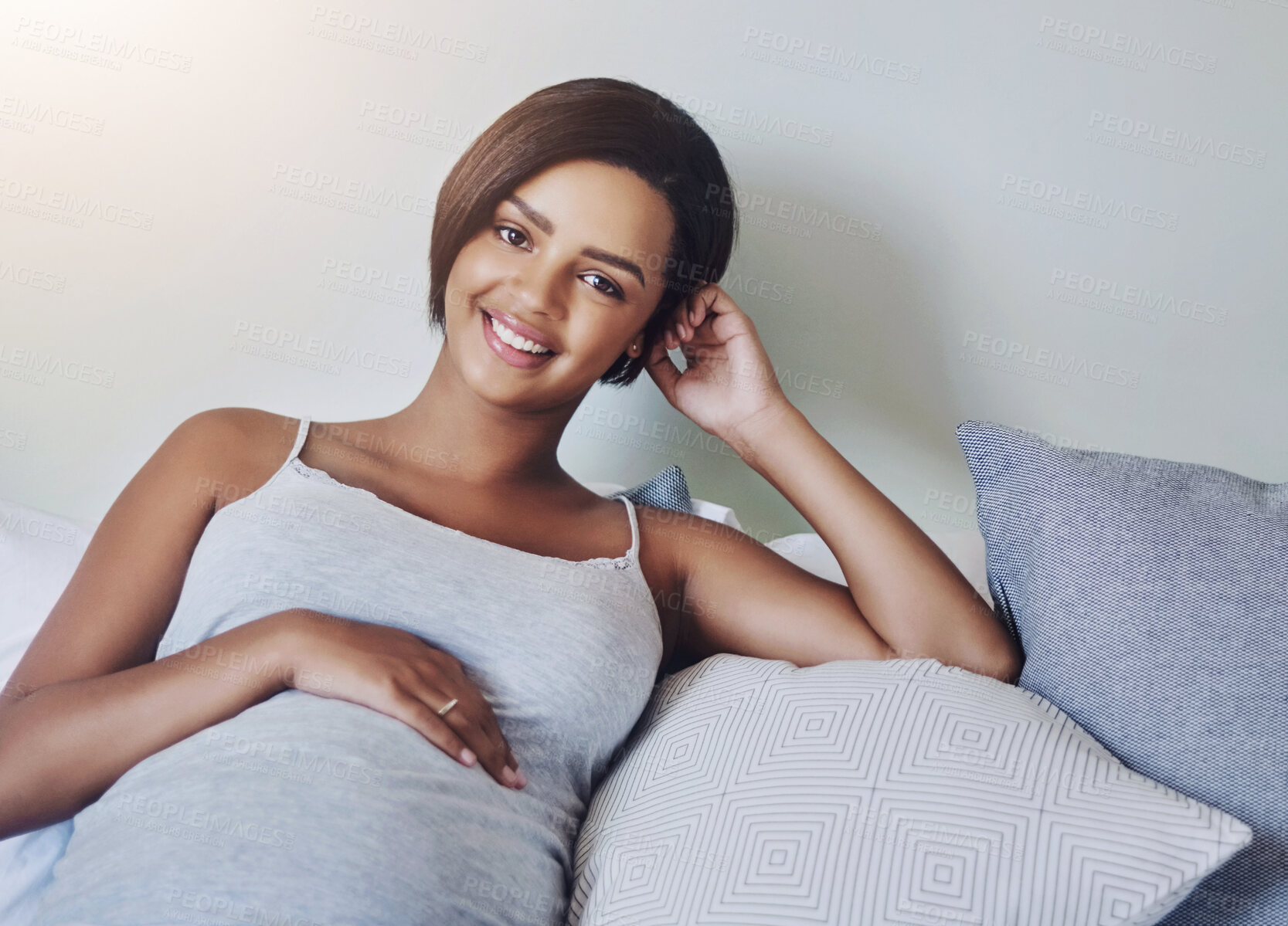 Buy stock photo Shot of a pregnant young woman relaxing on the bed at home