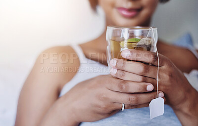 Buy stock photo Cropped shot of a young woman relaxing at home with a glass of tea