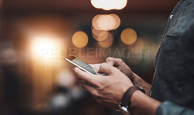 Buy stock photo Shot of an unrecognizable man browsing on a cellphone while standing inside of a beer brewery during the day