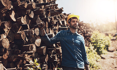 Buy stock photo Cropped shot of a lumberjack standing in front of a pile of wood