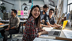 Happy, asian woman and designer with laptop and sketchbook for creative project in workshop. Business woman and artist with computer and paper for ideas, research and planning with team or coworkers