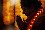 God, worship and Indian woman praying with beads, light and bokeh for healing, mindfulness and Hindu spirituality. Lighting, diya and mature person in prayer with zen, peace and gratitude or balance