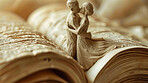 Book, story and sculpture of couple with kiss on page for romance, literature and love in poetry. Man, woman and statue with affection on novel for passion, storytelling and connection in marriage