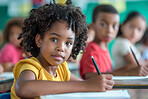 Girl, student and book in school and desk, learning institute and children together for education class. Child, writing and with study textbook, childhood and smile for development or growth