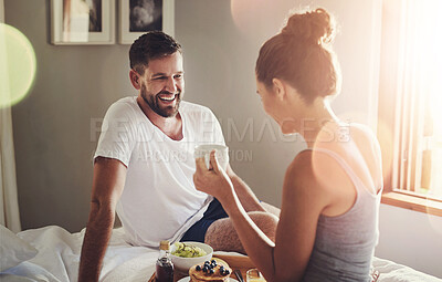 Buy stock photo Cropped shot of a happy young couple enjoying breakfast in bed together at home
