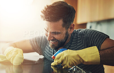 Buy stock photo Shot of a young man cleaning the kitchen counter at home
