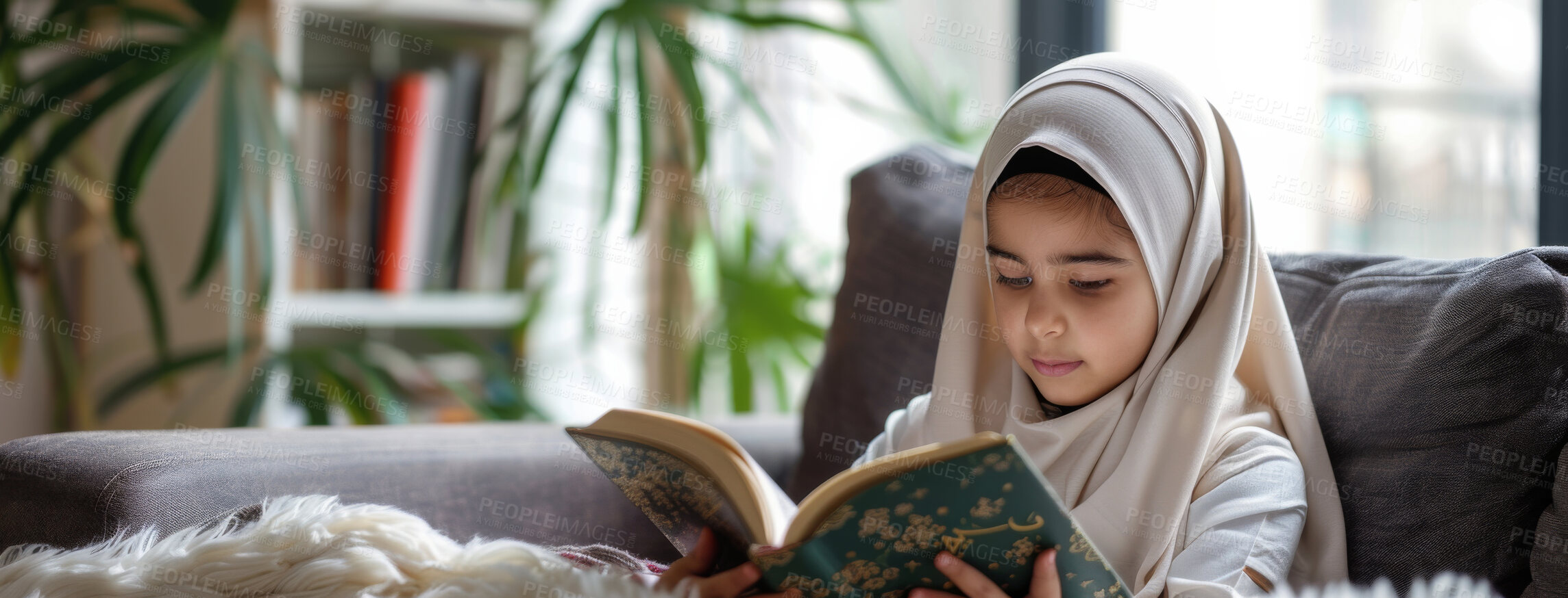 Buy stock photo Muslim, home and child reading Quran on sofa for faith, religion or worship on EID in living room. Islam, girl and kid study book for learning, education or spiritual knowledge on ramadan mubarak