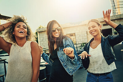 Buy stock photo Shot of a group of young women dancing and having fun together outdoors