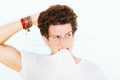Buy stock photo Thinking, confused and a man biting his tshirt in studio isolated on white background for crazy style. Face, doubt or expression with a young model scratching his head, looking clueless about an idea