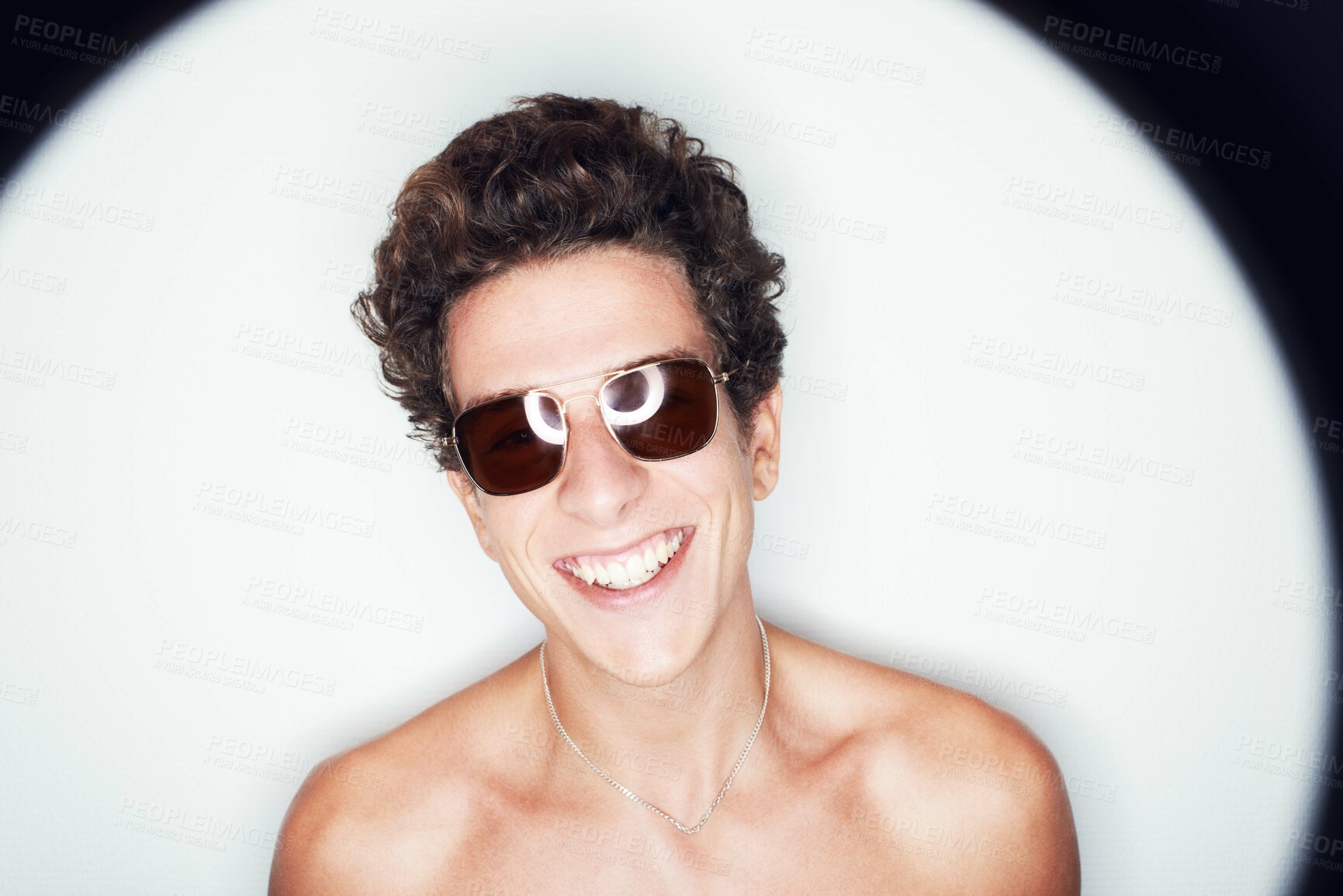 Buy stock photo Man, sunglasses and smile in studio with spotlight, fashion or shirtless with edgy punk style by background. Person, fashion and happy by halo for confidence, attitude or jewelry for trendy aesthetic