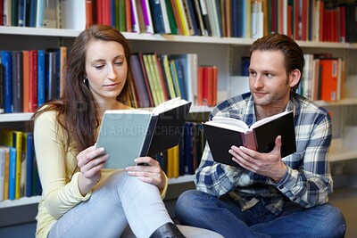 Buy stock photo Shot of a young man and woman bonding over their love for books