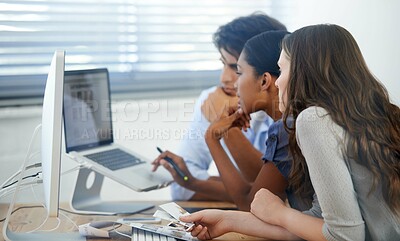 Buy stock photo Cropped shot of two young colleagues working at a desk