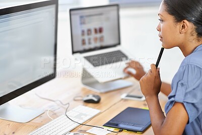 Buy stock photo Shot of a young professional looking at a computer screen at her desk