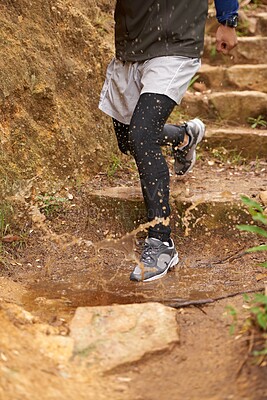 Buy stock photo Puddle, trail or legs of runner running in nature training, cardio exercise or endurance workout for wellness. Steps, splash or closeup of sports athlete on jog in a mountain outdoors for fitness