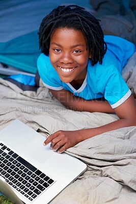 Buy stock photo A young boy using his laptop while away on a camping trip