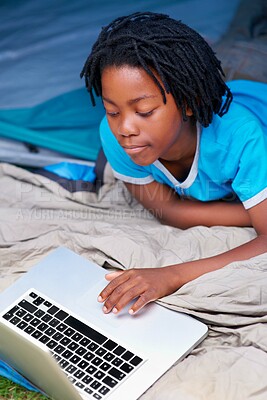 Buy stock photo Child, relax and play with laptop in tent with cartoon, movie or online games on holiday or vacation. Kid, smile and watch video on streaming, website or search on internet for computer elearning