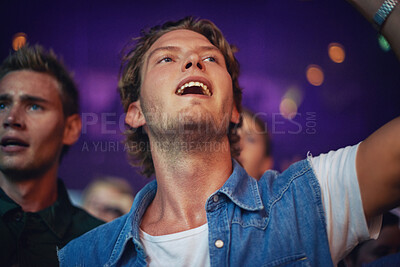 Buy stock photo An excited young man watching his favorite band perform live. This concert was created for the sole purpose of this photo shoot, featuring 300 models and 3 live bands. All people in this shoot are model released.