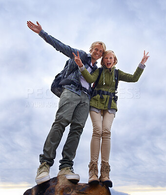 Buy stock photo Couple, hiking and excited on mountain top for travel, success and achievement with peace sign on cloudy sky. Portrait of happy people in backpack for trekking, journey or adventure with a low angle