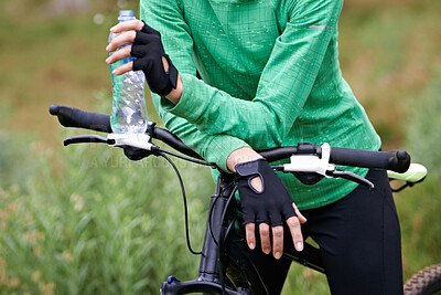 Buy stock photo Person, cyclist and hands with water bottle in nature with bicycle for cycling, fitness or break on off road trail. Thirsty biker, rider or athlete with beverage in forest, rest or outdoor workout