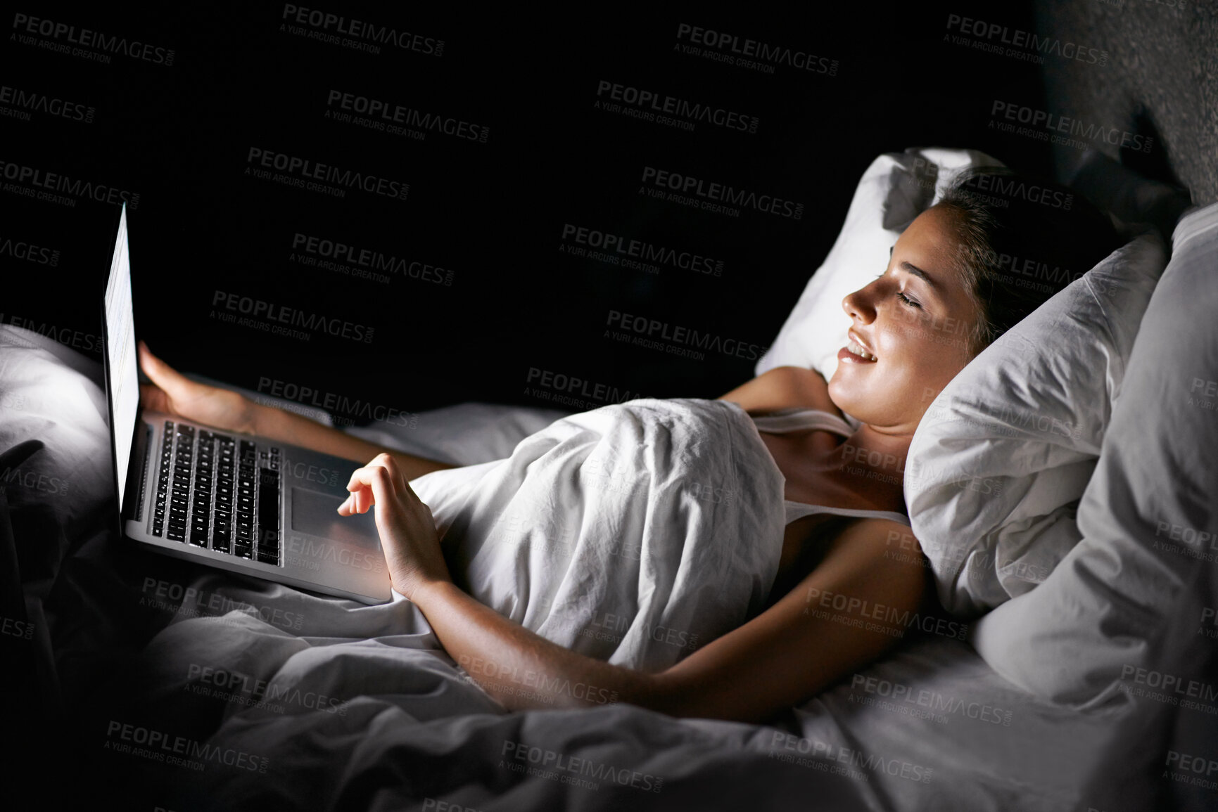 Buy stock photo Bedroom, laptop and night with woman streaming content, video or browsing social media in dark home. Bed, computer and subscription with young person in apartment to relax on weekend time off