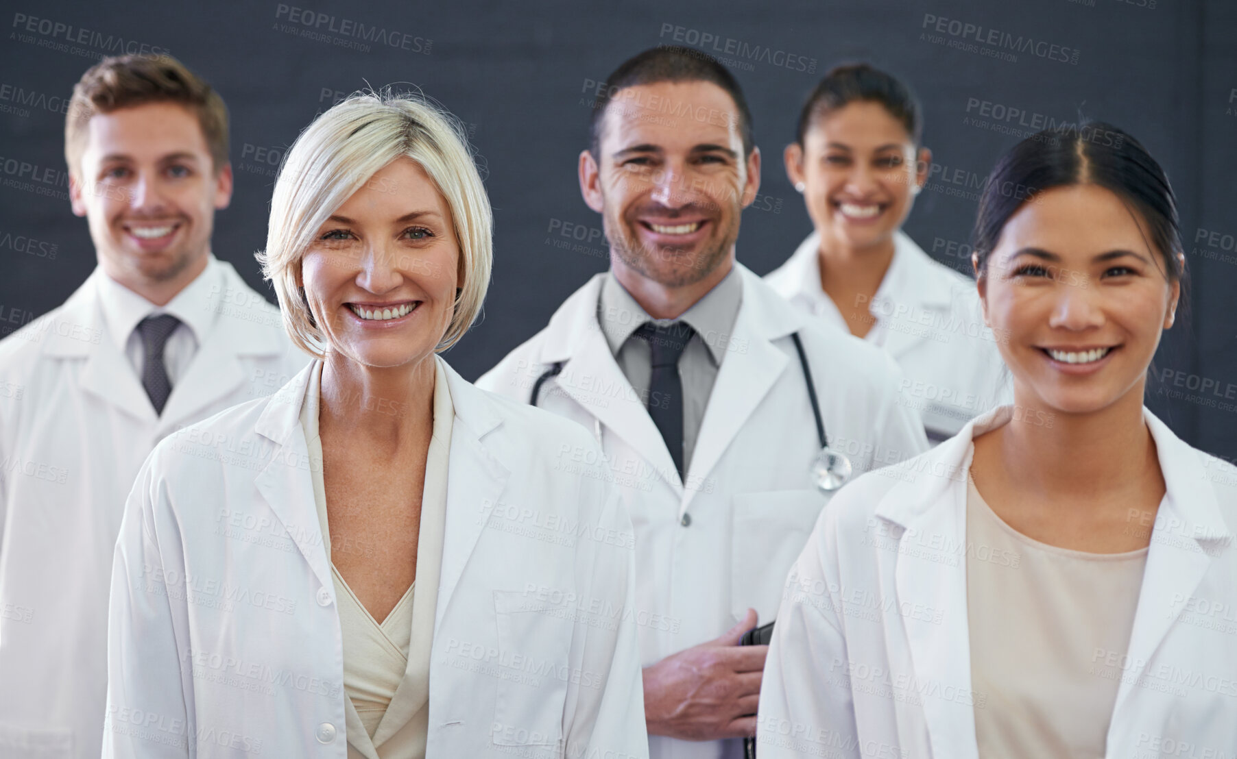 Buy stock photo Studio portrait of a team of doctors standing against a grey background