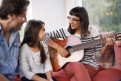 Buy stock photo Woman, music and playing guitar in living room for family, relaxing and enjoying together on couch. Performance, men and child with smile on sofa, entertainment and mother with musical instrument