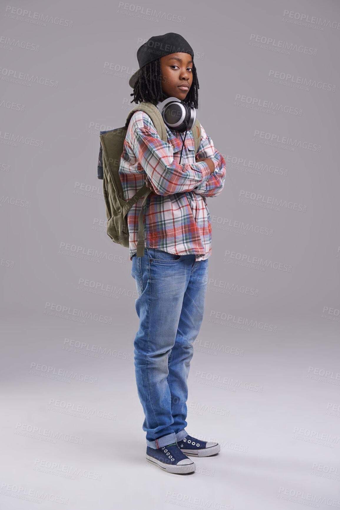 Buy stock photo Attitude, crossed arms and portrait of child on gray background with headphones for song, audio and radio. Student, school and young African boy with bag in trendy style, clothes and outfit in studio