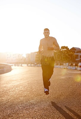 Buy stock photo Man, running and martial arts in street for exercise, training and cardio for health, stamina and tattoo in sunshine. Fighter, outdoor and road for workout in morning, sunrise and mma for wellness